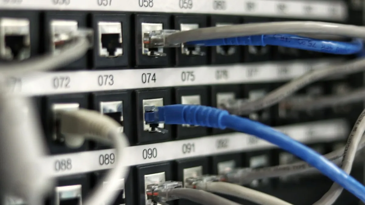 Câbles réseau Ethernet branchés sur un panneau de brassage dans un immeuble